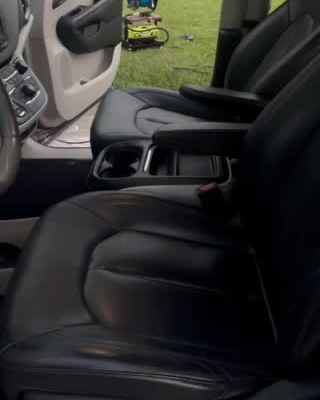 After: clean black leather front seats in the same minivan